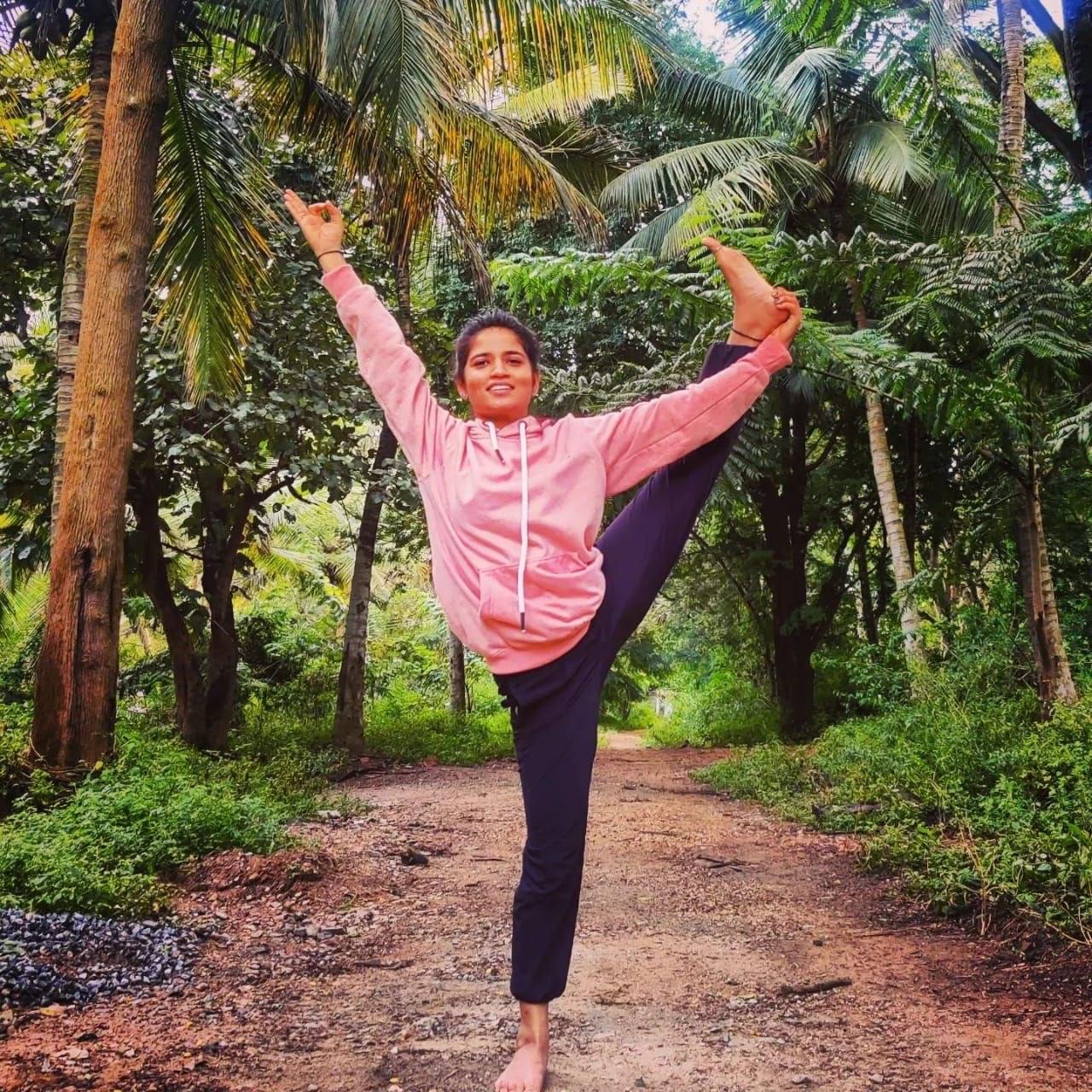 Dimple in a lush nature yoga pose